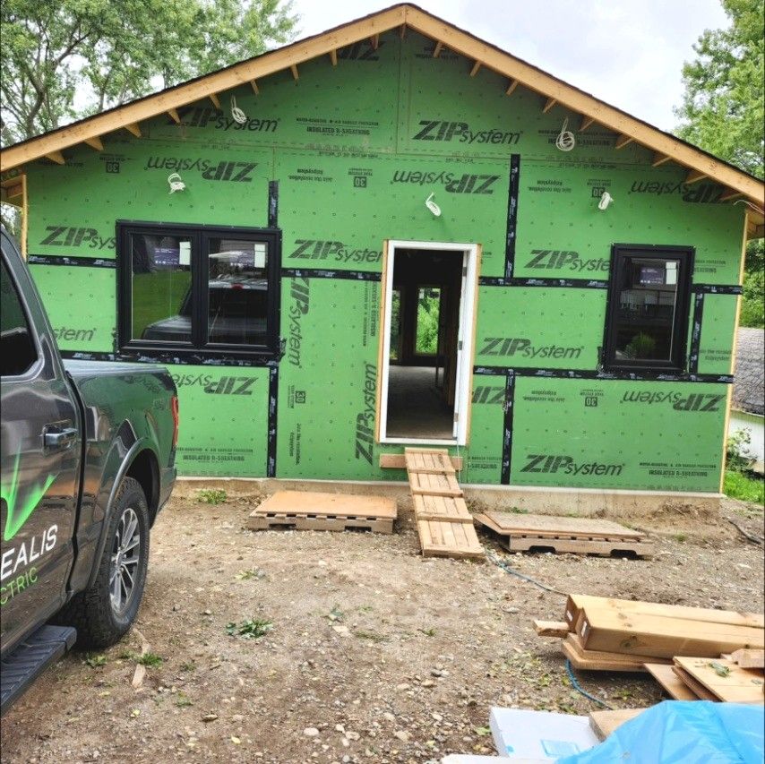 Borealis Electric truck parked beside a new house in ZIP System sheathing