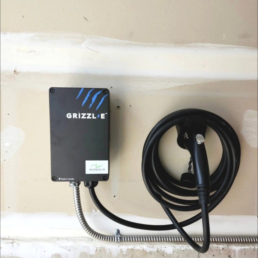 Grizzl-E Level 2 EV charger mounted in a garage with a Borealis Electric sticker