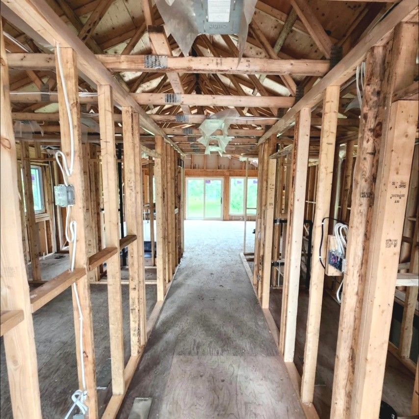 Framed hallway in a new home with boxes and cable run through the studs